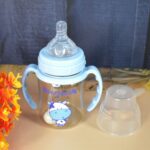 Plastic Baby Feeding Bottle with Handles, Cleaning brush & Straw (180 ML / 1 Pc) - Front View by Nari Haat, Indian et...
