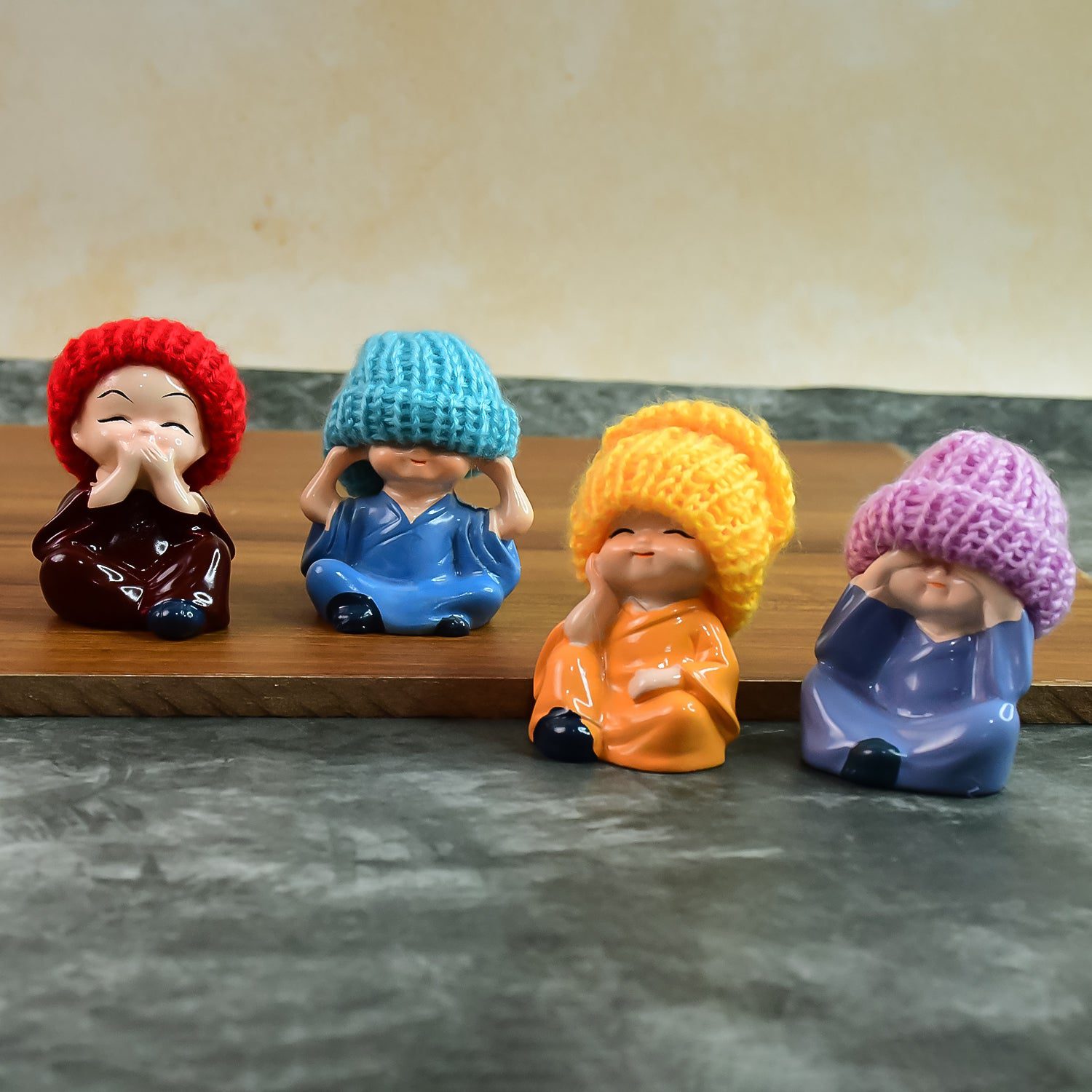 01_068409a1-9e20-4492-99fa-f04a29730438.jpg Decorative Resin Monk Buddha Showpiece Set of 4 with Traditional Straw Hats - Front View by Nari Haat, Indian ethnic ...