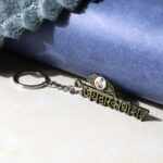 “Jai Dwarkadhish” Text Metal Keychain (1 Pc) - Front View by Nari Haat, Indian ethnic wear, women clothing, desig...