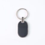 Elegant Black & Silver Oval Metal Keychain (1 Pc) - Sleeve Design by Nari Haat, Indian ethnic wear, women clothing, d...