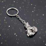 Premium Silver-Finish Metal Bal Krishna Eating Makhan Keychain (1 Pc) - Fabric Detail by Nari Haat, Indian ethnic wea...