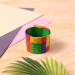 Colorful Snap Slap Bracelet Toy (1 Pc ) - Fabric Detail by Nari Haat, Indian ethnic wear, women clothing, designer suit