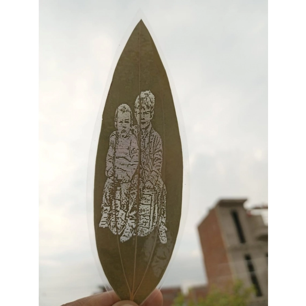 Engraved parent and child portrait on a natural leaf